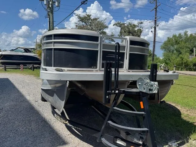 Slide: The Image of 2020 Bennington SX22 pontoon boat on trailer, parked outdoors under a clear blue sky. - 8