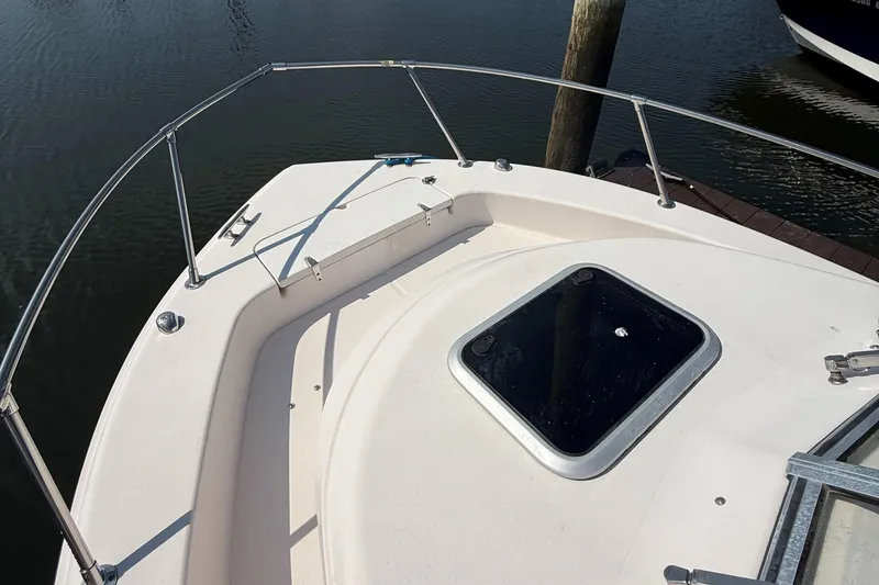 Slide: The Image of 2011 Grady-White 226 Seafarer WA boat deck with hatch, docked by water. - 9