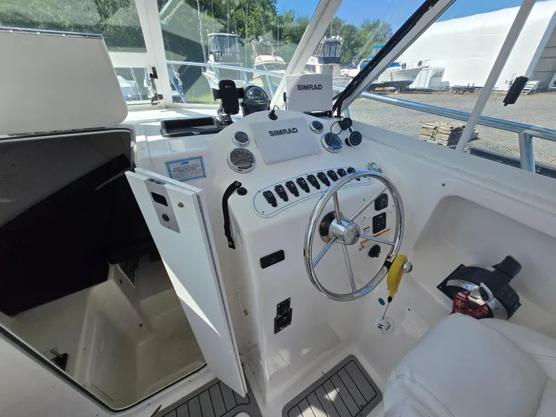 Slide: The Image of 2008 Baha Cruisers 277 GLE OB boat cockpit with steering wheel and Simrad navigation system. - 2