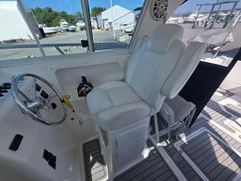 Slide: The Image of 2008 Baha Cruisers 277 GLE OB boat interior with steering wheel and white captain's chair. - 7