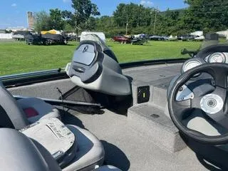 Slide: The Image of 2016 Tracker Pro Team 195 TXW boat interior with steering wheel and seats on grassy field. - 6