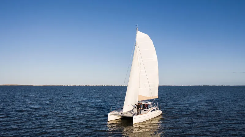 The Image of 2018 Maine Cat 38 LS sailing on open water under clear blue sky. - 0