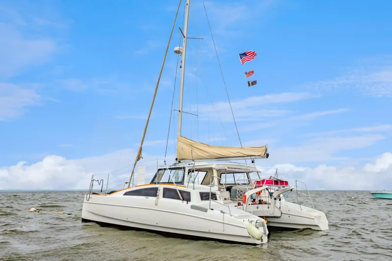 Slide: The Image of 2018 Maine Cat 38 LS catamaran sailing on calm waters under a clear blue sky. - 10