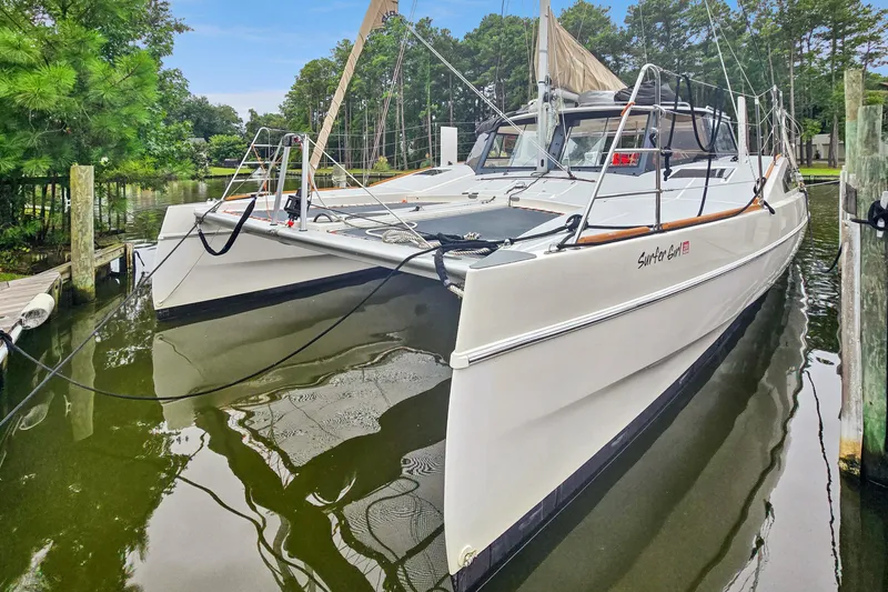 Slide: The Image of 2018 Maine Cat 38 LS catamaran docked in a serene marina setting. - 12