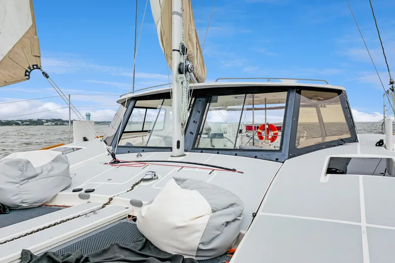 Slide: The Image of 2018 Maine Cat 38 LS sailboat on water, featuring spacious deck and sails. - 14