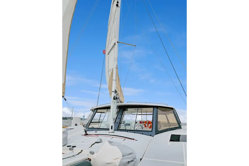 Slide: The Image of 2018 Maine Cat 38 LS sailboat with sails up against a clear blue sky. - 19