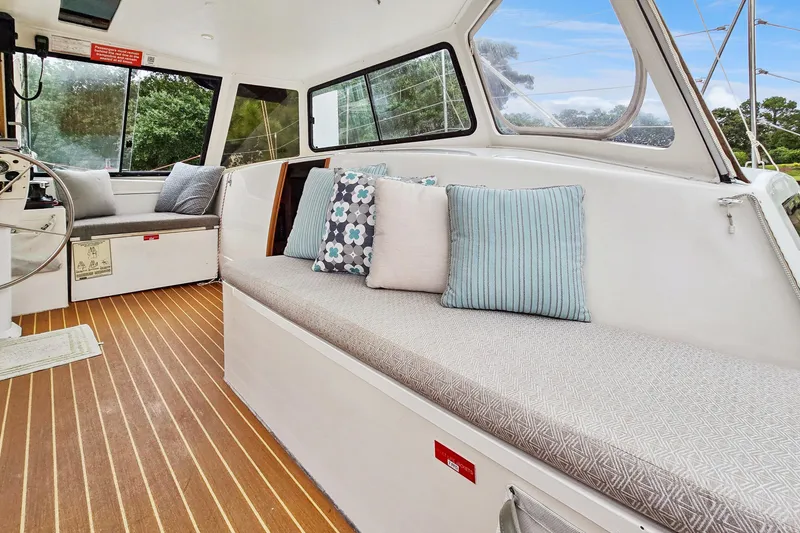 Slide: The Image of Interior of 2018 Maine Cat 38 LS with cushioned seating and striped pillows. - 49