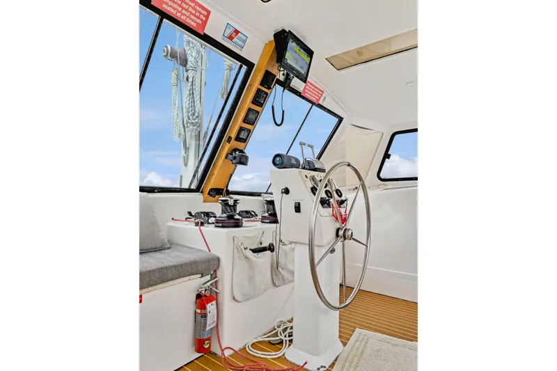 Slide: The Image of Helm of 2018 Maine Cat 38 LS with steering wheel, navigation equipment, and fire extinguisher. - 52