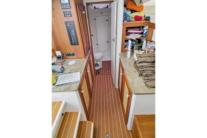 Slide: The Image of 2018 Maine Cat 38 LS interior with wood flooring, cabinets, and a compact bathroom. - 67