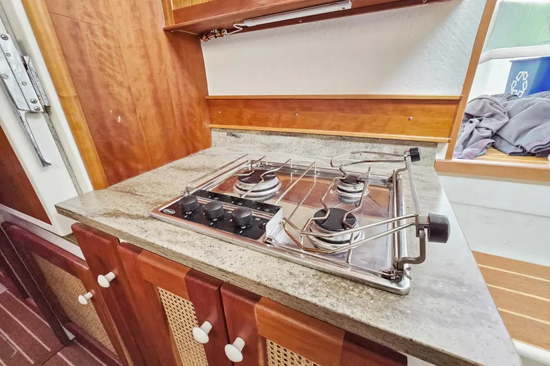 Slide: The Image of 2018 Maine Cat 38 LS yacht kitchen with two-burner stove and wooden cabinetry. - 69