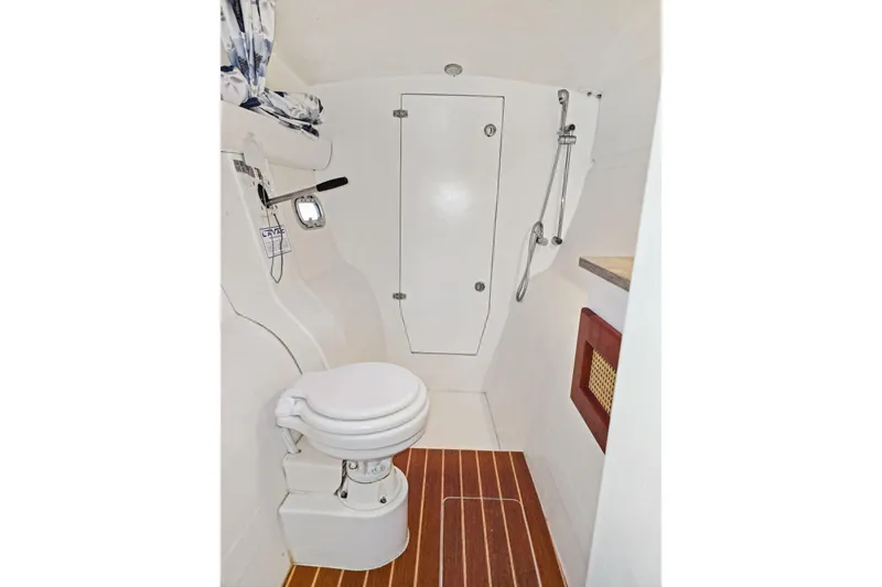 Slide: The Image of 2018 Maine Cat 38 LS boat bathroom with toilet, shower, and wooden floor. - 71