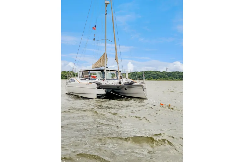 Slide: The Image of 2018 Maine Cat 38 LS catamaran sailing on a calm river under a clear blue sky. - 82
