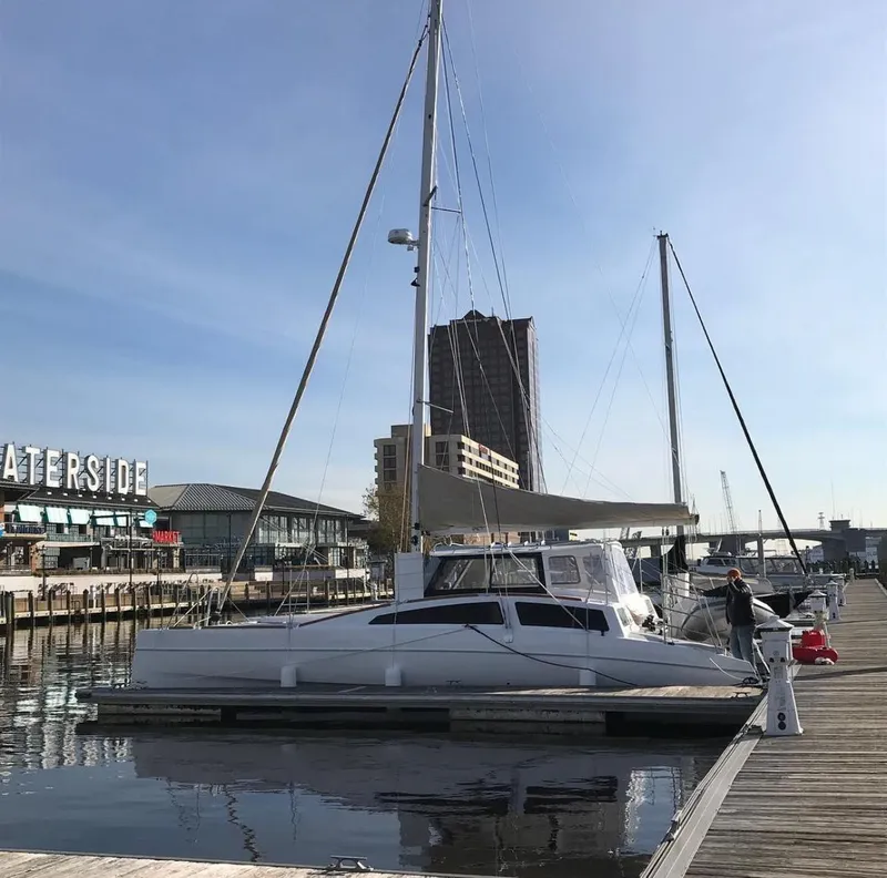 Slide: The Image of 2018 Maine Cat 38 LS catamaran docked at a marina with cityscape background. - 85
