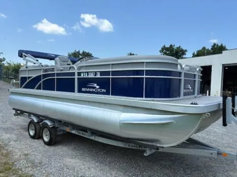 The Image of 2024 Bennington 22SVSR pontoon boat on trailer, parked outdoors under a clear sky. - 1