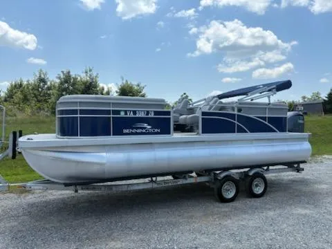 Slide: The Image of 2024 Bennington 22SVSR pontoon boat on trailer, under a clear blue sky. - 5