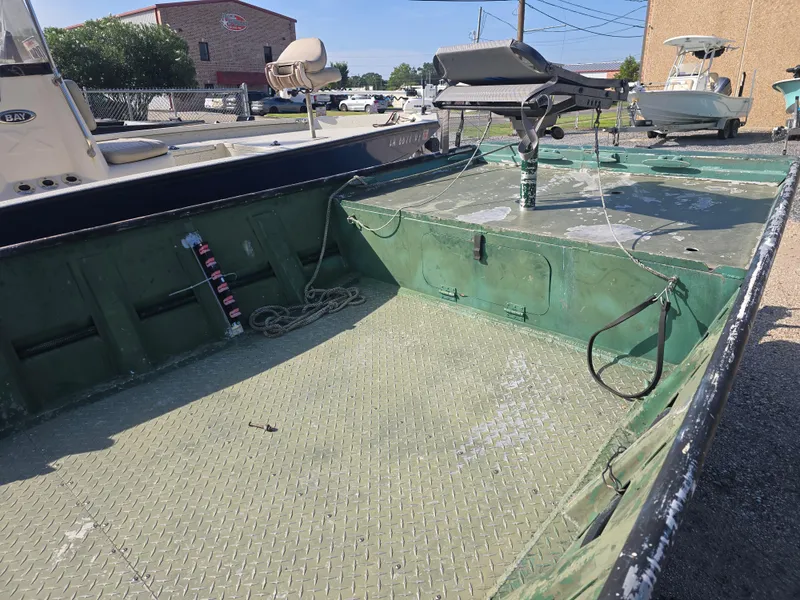 Slide: The Image of Open deck of a 2016 Custom Flat 16 boat with green interior and fishing equipment. - 5