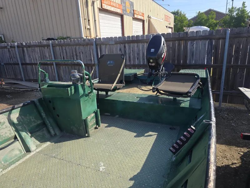 Slide: The Image of Custom Flat 16 boat, 2016 model, with Suzuki outboard motor, parked outdoors. - 6