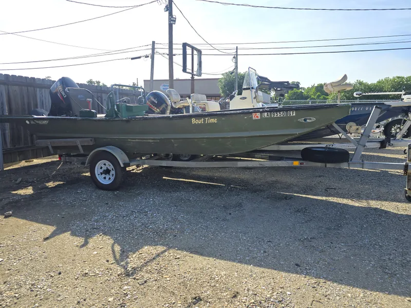 Slide: The Image of Custom Flat 16 boat on trailer, parked outdoors, labeled "Bout Time," 2016 model. - 9