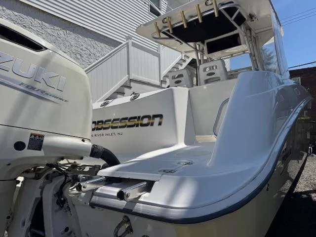 Slide: The Image of 2004 Boston Whaler 320 Outrage boat with Suzuki engine, docked near a building. - 1
