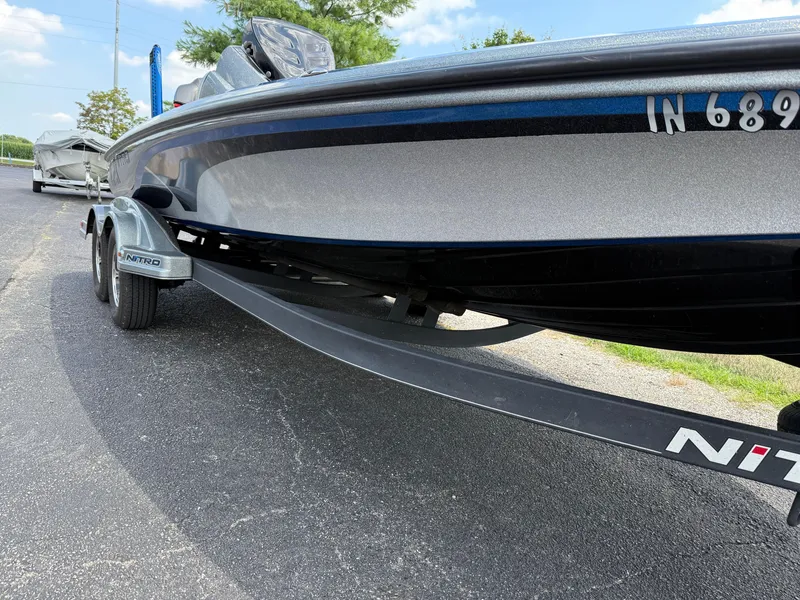 Slide: The Image of 2019 Nitro Z21 boat on trailer, parked on asphalt, under a clear sky. - 18