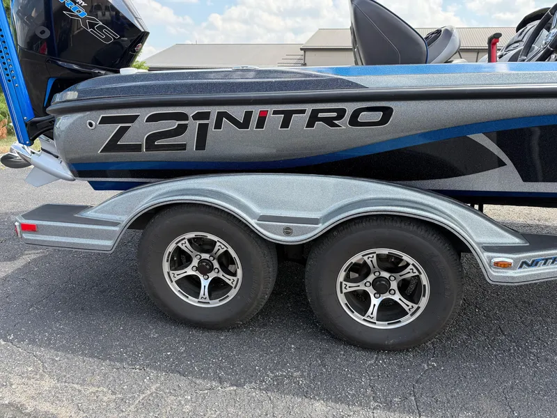 Slide: The Image of 2019 Nitro Z21 boat on trailer with dual wheels, blue and silver design. - 19