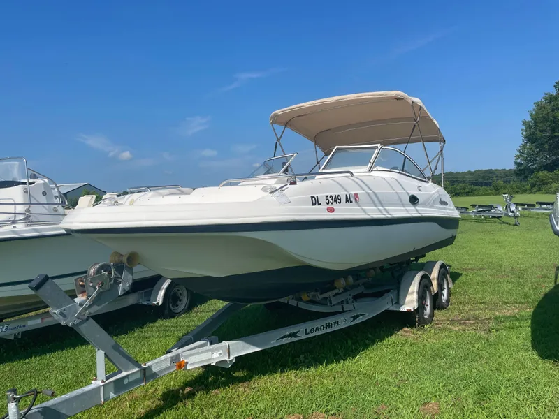 Slide: The Image of 2004 Hurricane 217 OB boat on trailer, parked on grass under clear blue sky. - 10