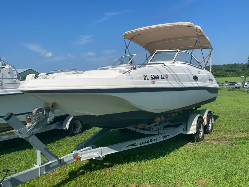 Slide: The Image of 2004 Hurricane 217 OB boat on trailer, parked on grass under clear blue sky. - 11