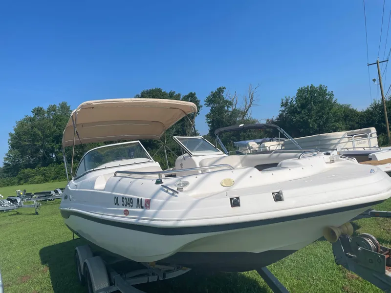 Slide: The Image of 2004 Hurricane 217 OB boat on trailer, parked on grass under clear blue sky. - 12