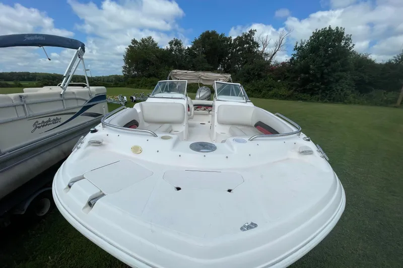 Slide: The Image of 2004 Hurricane 217 OB boat on grass, clear sky, adjacent to another boat. - 18