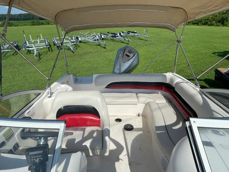 Slide: The Image of 2004 Hurricane 217 OB boat interior with seating and canopy on grassy field. - 5