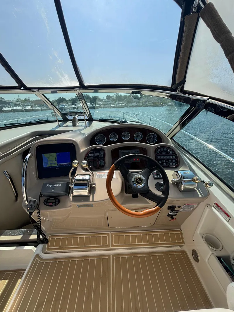 Slide: The Image of Cockpit of 2004 Sea Ray 320 Sundancer with steering wheel and navigation system. - 14