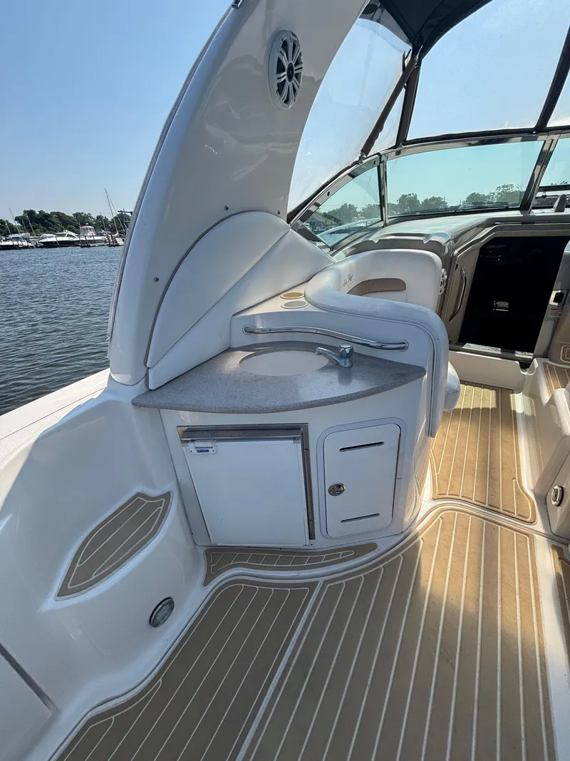 Slide: The Image of 2004 Sea Ray 320 Sundancer boat interior with kitchenette and seating area. - 23