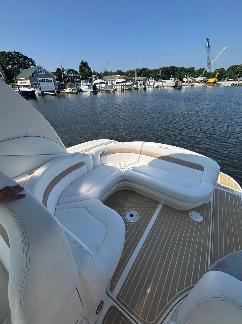Slide: The Image of 2004 Sea Ray 320 Sundancer boat with white seating, docked in a marina. - 27