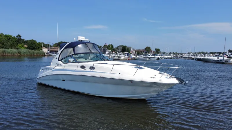Slide: The Image of 2004 Sea Ray 320 Sundancer yacht on calm water near marina. - 3