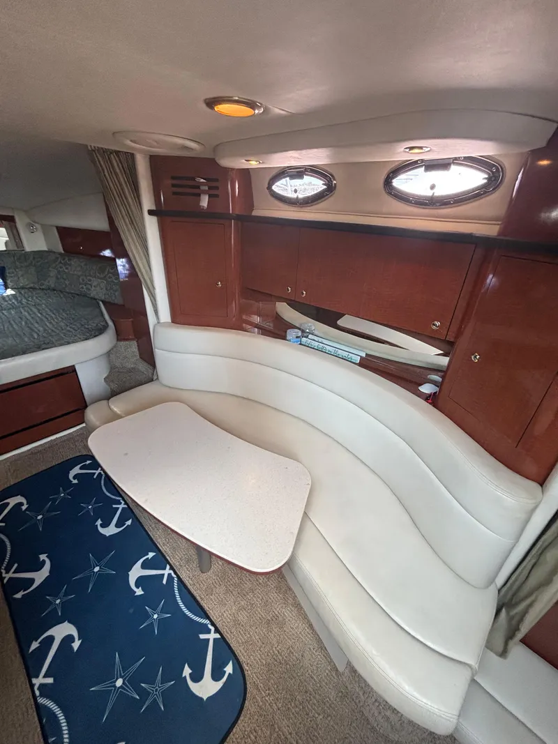 Slide: The Image of 2004 Sea Ray 320 Sundancer cabin interior with curved seating and nautical decor. - 30