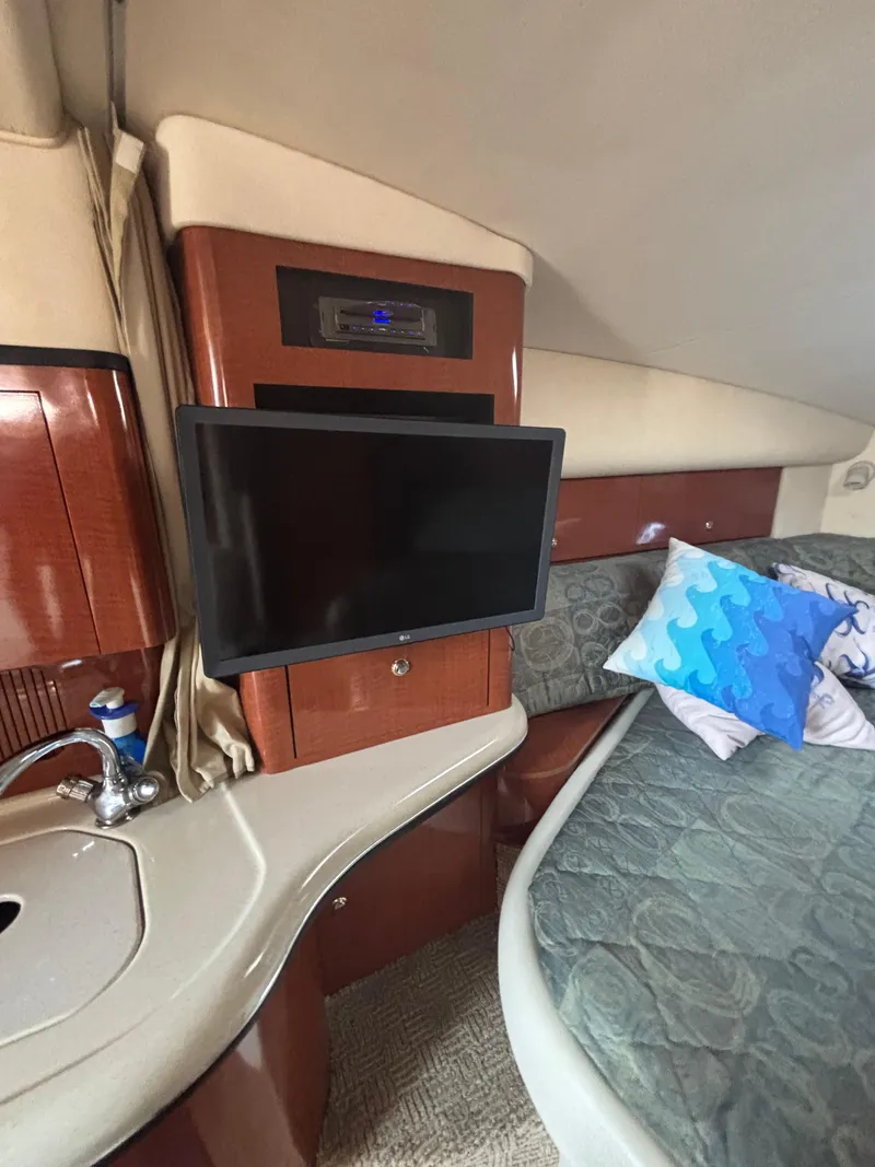 Slide: The Image of 2004 Sea Ray 320 Sundancer cabin interior with TV, sink, and bed. - 31