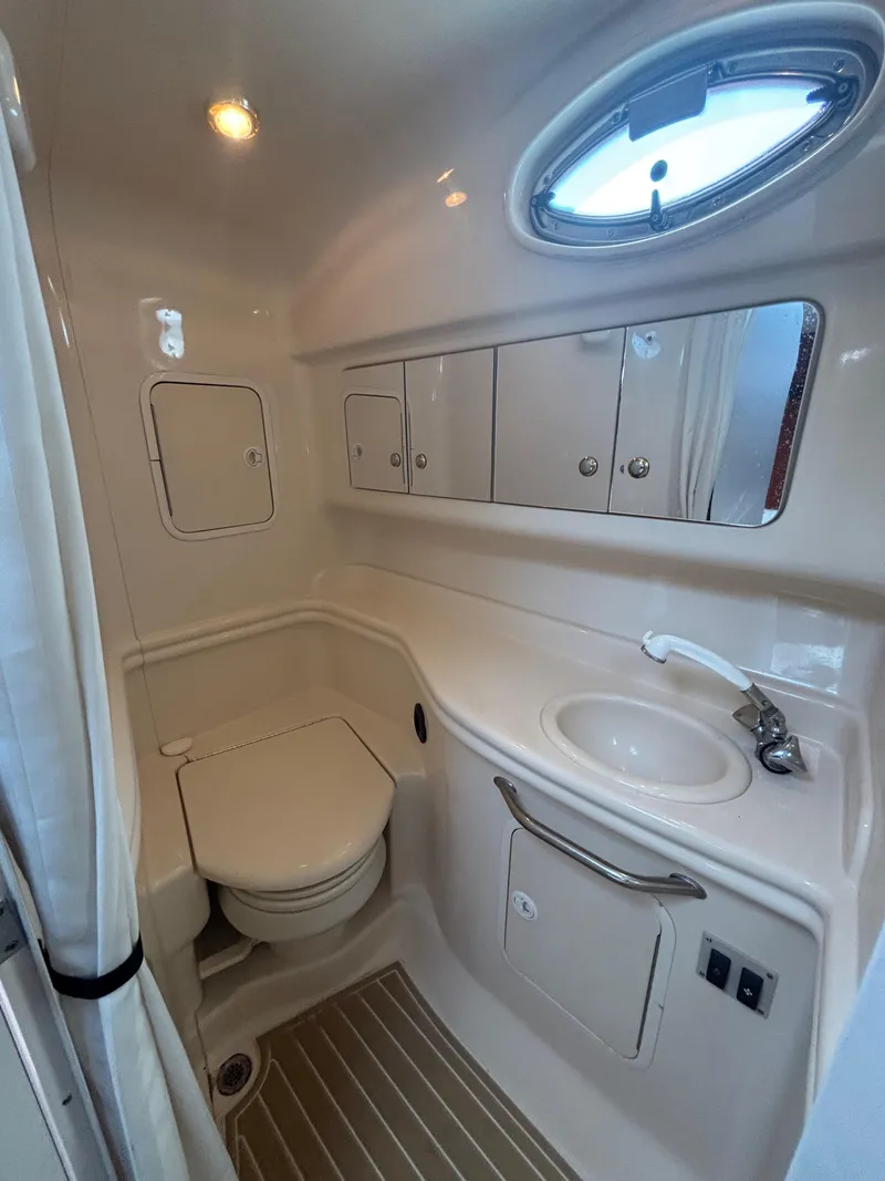 Slide: The Image of 2004 Sea Ray 320 Sundancer bathroom with sink, toilet, and storage cabinets. - 35