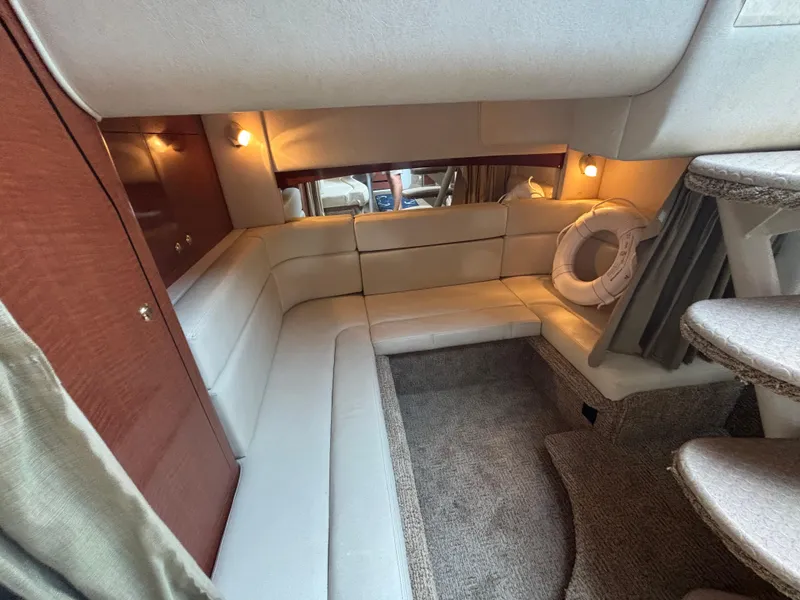 Slide: The Image of Interior of 2004 Sea Ray 320 Sundancer yacht with beige seating and carpeted flooring. - 36