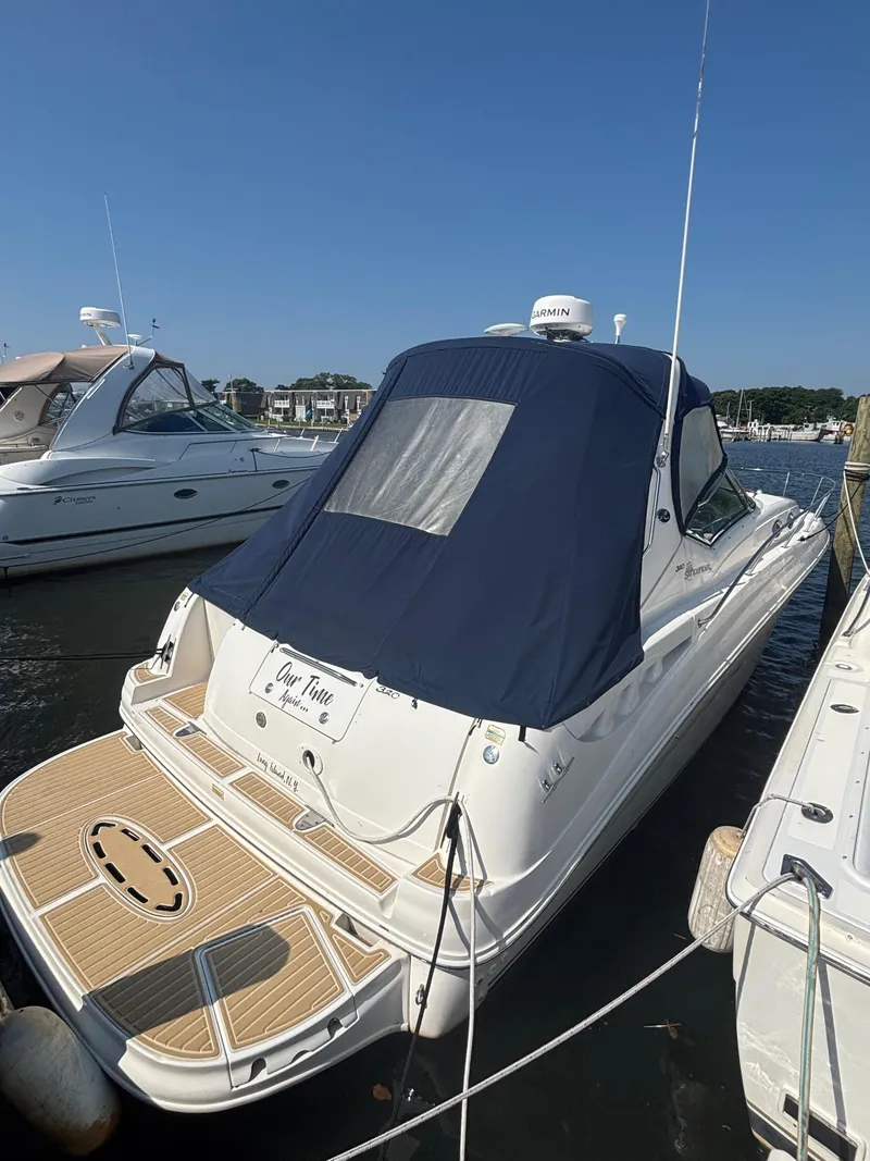 Slide: The Image of 2004 Sea Ray 320 Sundancer docked with blue cover, sunny day, marina background. - 37