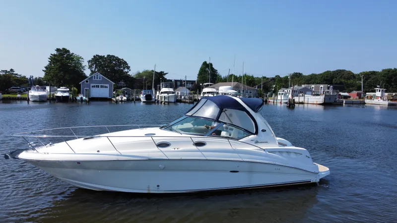 Slide: The Image of 2004 Sea Ray 320 Sundancer yacht docked in a serene marina setting. - 6