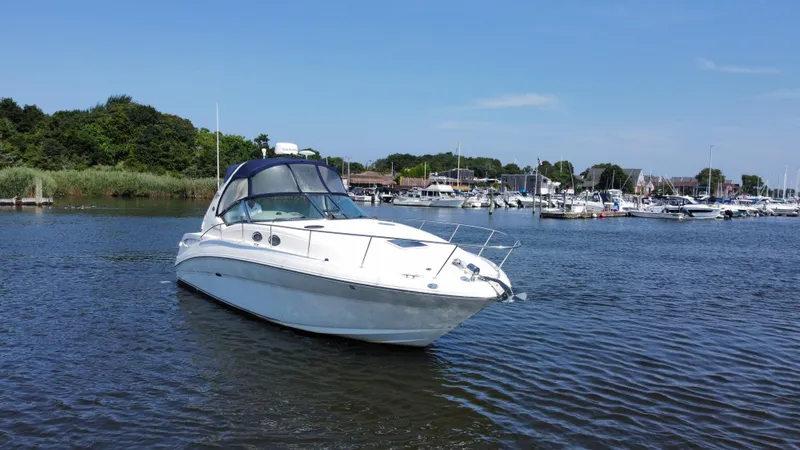 Slide: The Image of 2004 Sea Ray 320 Sundancer boat on calm water near marina. - 8