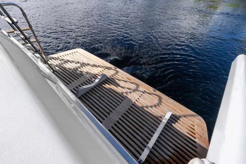 Slide: The Image of Teak swim platform on 1995 Itama 46 yacht, overlooking calm water. - 13