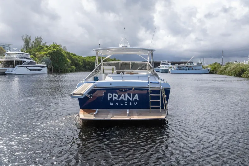 Slide: The Image of 1995 Itama 46 yacht on water, rear view with "Prana Malibu" text. - 3