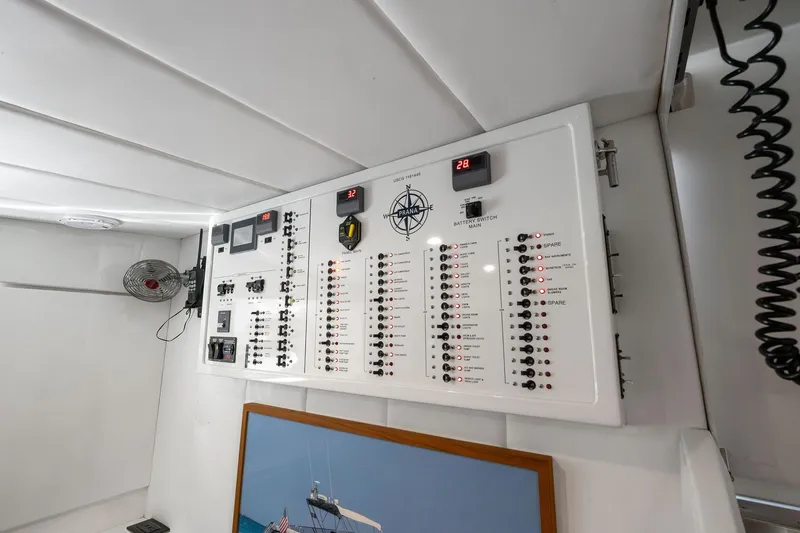 Slide: The Image of Electrical control panel inside a 1995 Itama 46 yacht, featuring switches and displays. - 33