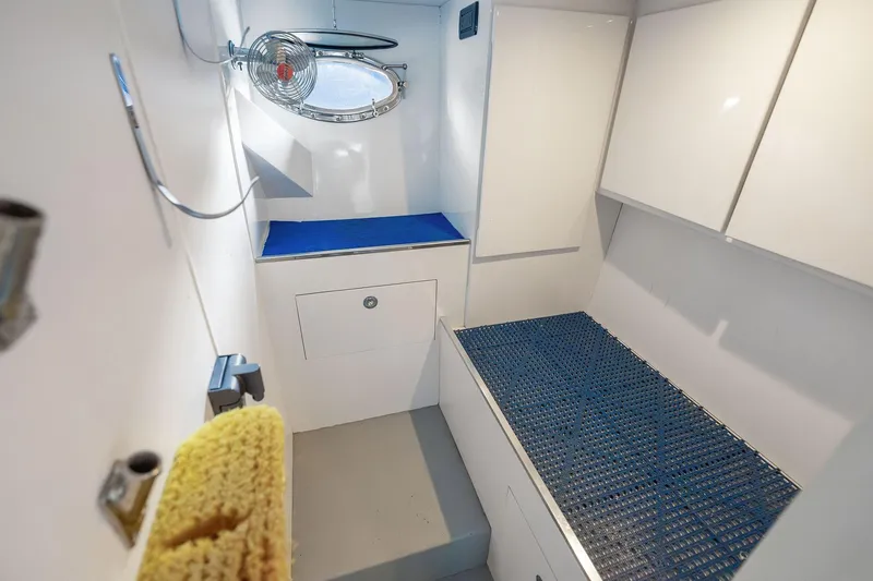 Slide: The Image of Interior of 1995 Itama 46 yacht, featuring white cabinetry and blue accents. - 35