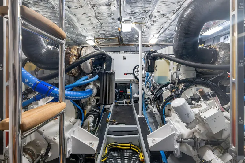 Slide: The Image of Engine room of a 1995 Itama 46 yacht, featuring complex machinery and piping. - 41