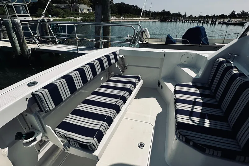 Slide: The Image of 2007 Sabreline 34 Express boat interior with striped seating at a marina. - 11