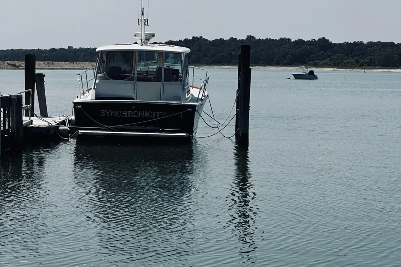 Slide: The Image of 2007 Sabreline 34 Express boat docked on calm water, named "Synchronicity." - 111
