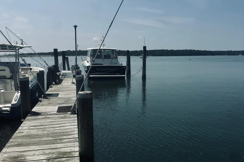 Slide: The Image of Docked 2007 Sabreline 34 Express boat on calm water under clear sky. - 113