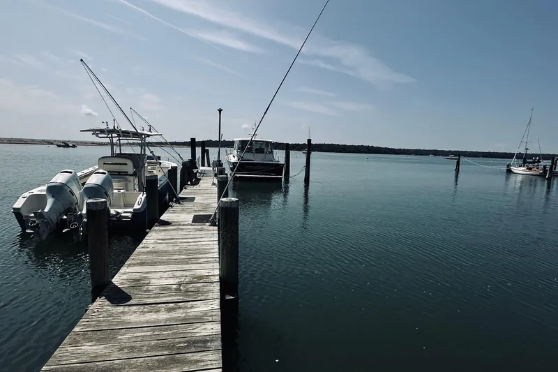 Slide: The Image of Docked boats at a serene marina, featuring a 2007 Sabreline 34 Express. - 114